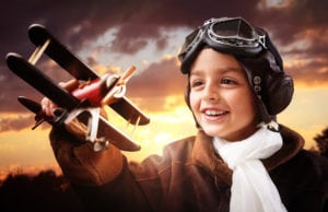 Boy wearing old-fashioned aviator hat, scarf and goggles
